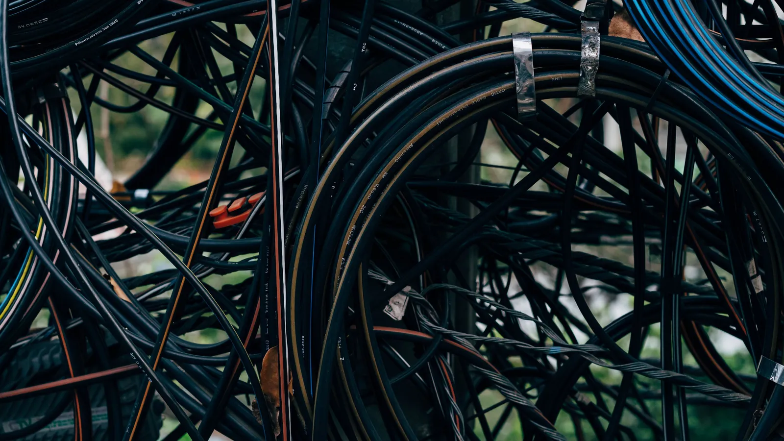 A close-up of a dense tangle of electrical wires outdoors