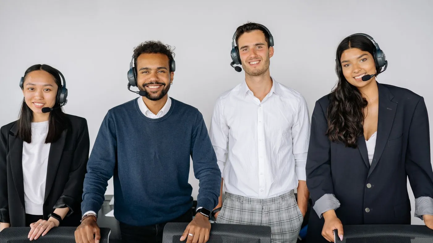 A group of customer service representatives wearing headsets in an office